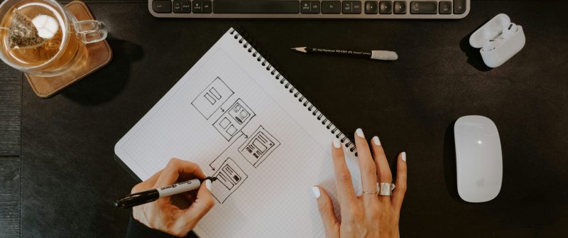 Persona planificando contenido para redes sociales en cuaderno con esquemas de publicaciones