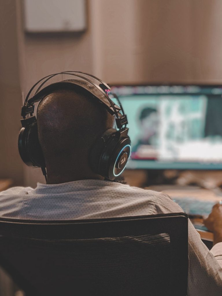 Persona con auriculares editando un vídeo en su ordenador